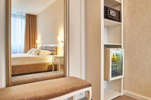 a hotel room with a bed and a mirror at Continental Forum Sibiu in Sibiu