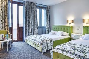 a hotel room with two beds and a window at Continental Forum Sibiu in Sibiu +110 photos