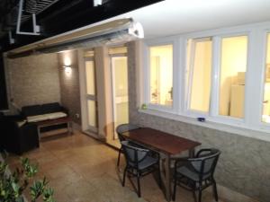 a table and chairs in a room with windows at Appartamento Villa Elison in Lazise
