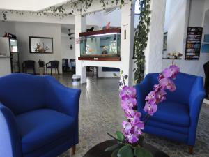 a lobby with two blue chairs and a fish tank at Pousada Torre Del Mar in Ubatuba