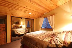 Un dormitorio con dos camas y techo de madera. en Summit Ski-Inn Ski-Out, en Big Bear Lake
