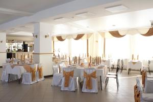 a banquet hall with white tables and chairs at Yasnaya Polyana in Arzamas