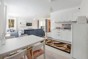 a kitchen and living room with a white refrigerator at Apartamenty Sun & Snow Szkolna in Międzywodzie