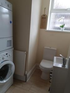 a bathroom with a toilet and a washing machine at Tunstall Serviced Home in Sunderland