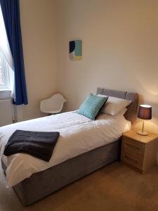 a bedroom with a bed with a blue pillow on it at Tunstall Serviced Home in Sunderland