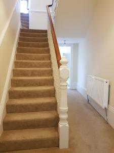 a staircase in a home with a white stair case at Tunstall Serviced Home in Sunderland