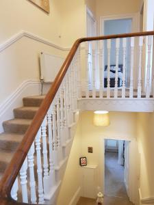 a staircase in a home with a white stair case at Tunstall Serviced Home in Sunderland