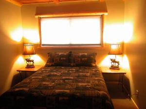 a bedroom with two lamps and a bed with a window at Moonridge Ski Pad in Big Bear Lake