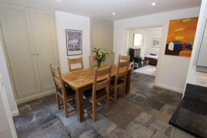 a dining room with a wooden table and chairs at Binswood Garden Apartment in Leamington Spa