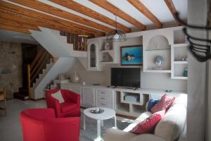 a living room with red chairs and a tv at La Dama del Mar in Telde