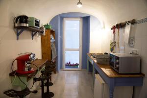 a kitchen with a counter with a microwave and a window at A mi Manera in Sassari