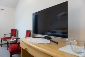 TV de pantalla plana grande en la parte superior de una mesa en Restaurant and rooms Kotlar en Kobarid