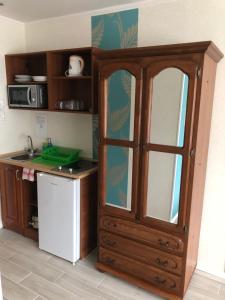 a kitchen with a large wooden cabinet with glass doors at Mosoly Apartman in Szeged