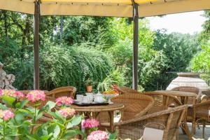 un patio con mesa y sillas bajo una sombrilla en Villa Benni B&B, en Bolonia