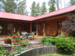 eine Hütte mit einer Terrasse, einem Tisch und Stühlen in der Unterkunft Blue Grouse Country Inn B&B in Clearwater