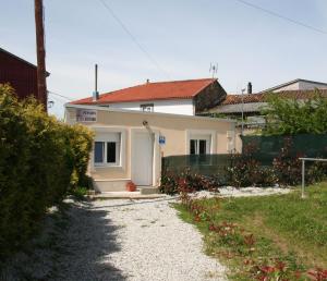 a white house with a gate and a gravel driveway at O Cruceiro in Palas de Rei