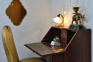 a desk with a lamp on top of it next to a chair at Hotel Domstern in Cologne