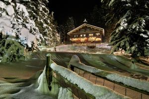 a log cabin in the snow at night at Haus Abendrot in Sankt Anton am Arlberg