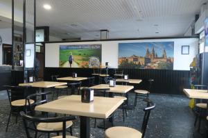 a dining room with tables and chairs and a large screen at Hotel Camiño do Mar in Urdilde