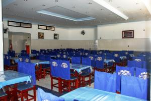 uma sala de jantar com mesas azuis e cadeiras vermelhas em Paradise Palace Hotel em Aparecida