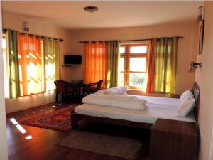 1 dormitorio con 2 camas en una habitación con ventanas en Hotel Ladakh Heaven, en Leh