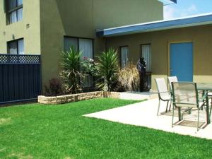 a patio with a table and chairs in a yard at Otway Gate Motel in Colac