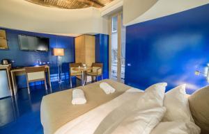 a blue bedroom with a bed with two pillows at Chiaia 197 Deluxe Residence in Naples