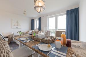 Ferienwohnungen Rosengarten في بورغيريندي-ريثفيش: غرفة معيشة بها طاولة وأريكة