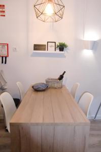 a wooden table with white chairs and a light fixture at The Surf Studio - Ericeira in Ericeira