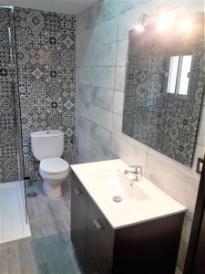 a bathroom with a toilet and a sink and a mirror at Apartamentos Sol Compañia in Úbeda