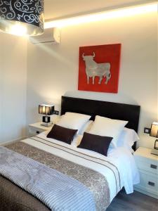 ウベダにあるApartamentos Sol Compañiaのベッドルーム1室(羊の赤い写真付)