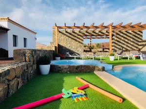 a backyard with a pool with baseball equipment on the grass at Casa palmito in Tesejerague