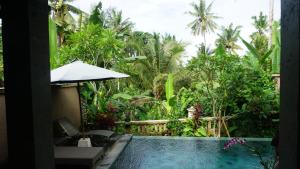 einen Pool vor einem Garten mit Bäumen in der Unterkunft Villa Cilinaya Ubud in Ubud