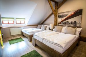 dwa łóżka w pokoju z drzewem na ścianie w obiekcie Tylova Apartments w mieście Kutná Hora