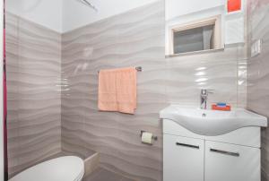 ein Badezimmer mit Waschbecken und Toilette in der Unterkunft Jakov in Postira