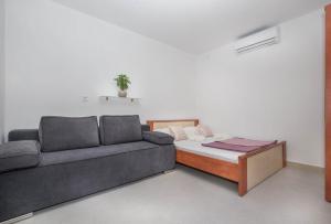ein Wohnzimmer mit einer Couch und einem Bett in der Unterkunft Jakov in Postira