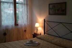 - une chambre avec un lit doté d'une lampe et d'une fenêtre dans l'établissement Agriturismo Diciocco, à Venturina Terme