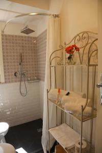 a bathroom with a shower and a shelf with towels at Casa Elena in Ragusa