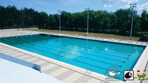 a large swimming pool with blue water at Apartment Koral in Ruma