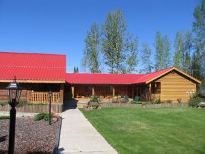 a log cabin with a red roof and a yard at Blue Grouse Country Inn B&B in Clearwater