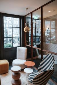 a living room filled with furniture and a large window at The Times Hotel in Amsterdam
