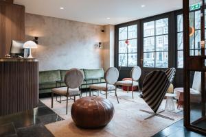 um átrio com cadeiras, um sofá e janelas em The Times Hotel em Amsterdã