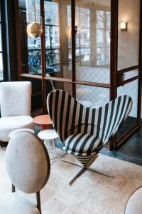 une chambre avec des chaises, des tables et une fenêtre dans l'établissement The Times Hotel, à Amsterdam