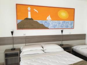 a bedroom with two beds and a painting on the wall at Hotel Corallo in Fregene
