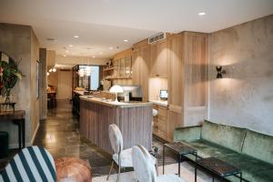 a kitchen with wooden cabinets and a bar with white chairs at The Times Hotel in Amsterdam