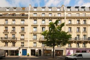 um grande edifício com uma árvore em frente em Melia Paris Champs Elysées em Paris