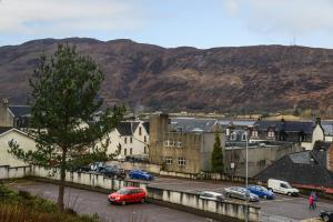 a city with cars parked in a parking lot with mountains at No. 1 Caberfeidh in Fort William
