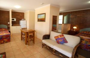 a living room filled with furniture and a table at Rubyvale Motel & Holiday Units in Rubyvale