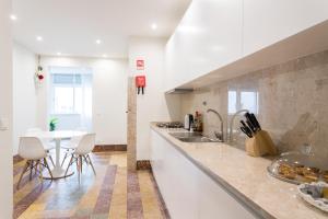 eine Küche mit einem Tisch und einer weißen Arbeitsplatte in der Unterkunft Cruz Apartments in Lissabon