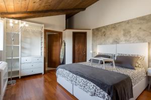 ヴェローナにあるRooms Castelvecchio - Palazzo Canossaの木製の天井が特徴のベッドルーム1室(大型ベッド1台付)